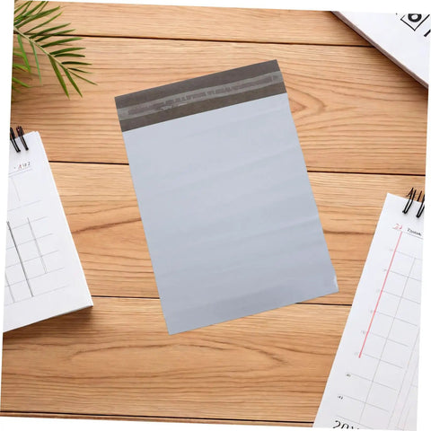 Self-Seal White Poly Mailer Bags 100 Pack 10x14 Inches Waterproof And Tear-Resistant Shipping Bags on table with stationery