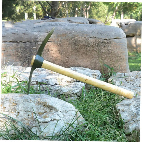 Steel Garden Pickaxe With Wooden Handle For Weeding And Soil Cultivation, Durable Hand Hoe resting on rocks outdoors.