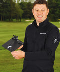 Man holding Pro Grade Golf Swing Trainer Plate With 2 Premium Gold Alignment Rods, outdoors, showing product size and use.