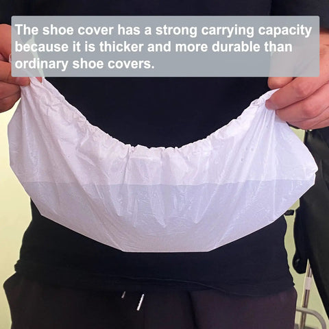 Person holding durable white disposable shoe cover from Disposable Shoe Covers Pack Of 200 100 Pairs Built Tough Waterproof Non Slip Boot Covers One Size Fits Most For Rain Cleaning Indoor Floor Protection White, showing thickness and strength.
