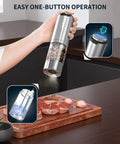 Electric Pepper Grinder Stainless Steel Rechargeable With External Coarseness Dial 95ml Capacity White LED Light Silver Finish For Freshly Ground Pepper On The Fly in use over steak