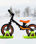 Balance Bike And Scooter Sledge Board Kit For Winter Fun with green ski attachments on snowy background, side view