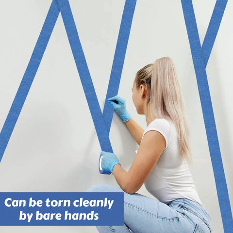 Person applying Blue Painter Tape Bulk Pack 12 Rolls 2 Inch Wide 55 Yards Each for wall painting, ensuring clean lines.