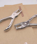Dual Hole Punch Set With One Quarter Inch And One Eighth Inch Holes on brown paper, stainless steel ergonomic handheld punch