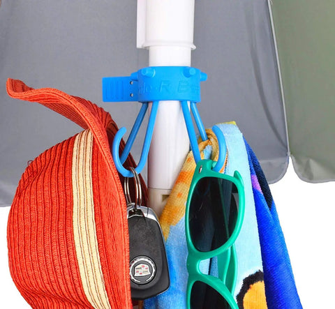 Stainless Steel Umbrella Hook For Beach Gear And Towel Bag Holder Keeps Sand Off Tables And Surfaces Patio Accessory Fits All Standard Umbrella Poles Includes Clear Adapter For Skinny Poles Made In USA Blue holding hats and towels.