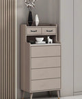 Beige dresser with drawers and decorative items, located in a modern room corner with wood panel accent wall.