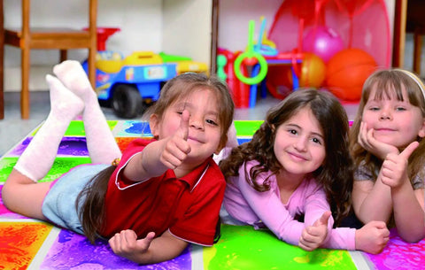 Children playing on Six Assorted Color 12 by 12 Inch Liquid Floor Tiles Set for Kids, showing vibrant sensory tiles in use.
