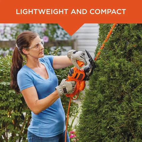 Woman using Corded 17 Inch Hedge Trimmer With 3.2 Amp Motor, Dual Action Blades For Reduced Vibration And Cleaner Cuts on bush