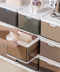 Person organizing clothes in Three-Pack Stackable Clothes Organizer Bins With Sliding Rails And Removable Lids, drawer style storage.