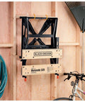 Portable Work Bench With Vise And Adjustable Height Legs stored in compact form on a wall, Heavy Duty Steel Frame Supports Up To 450 Lbs