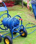 Heavy Duty Slick Metal Hose Reel With Smooth Maneuver Four Wheel Garden Cart Plus 100 Feet Water Pipe No Sweat Outdoor Setup on grass.