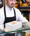 Baker with Kraft Paper Cookie Boxes With Clear Window Safe And Odorless Bulk Pack Of 50 Mini Treat Boxes on display