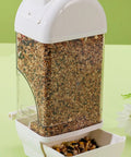 Bird Parent Approved House Shaped Automatic Bird Feeder And Water Dispenser For Parrots And Parakeets Clear large capacity feeder containing mixed seeds.