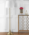 63 Inch Brass Gold Modern Glam LED Floor Lamp With White Linen Empire Shade next to decorative console in living room