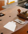 Workbench with clear rectangular tool, resembling Clear Eye Safety Guard for Bench Grinders, Easy Install Bench Cover Replacement.