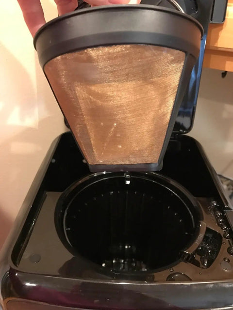 Gold Tone Permanent Coffee Filter For 12 Cup Coffee Makers Including Krups Savoy Braun DeLonghi being placed in coffee maker.