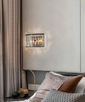 Modern K9 Crystal Wall Sconce Flush Mount LED Light With Matte Black Finish And Two Elegant Fan Shades For Bedroom Living Room Or Bathroom Decor That Is Truly High End And Straight Up Stunning mounted beside a bed.
