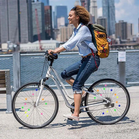Woman biking with colorful star shaped spoke beads for kids bikes clip on plastic spoke beads set, 36 pieces decorating wheels.