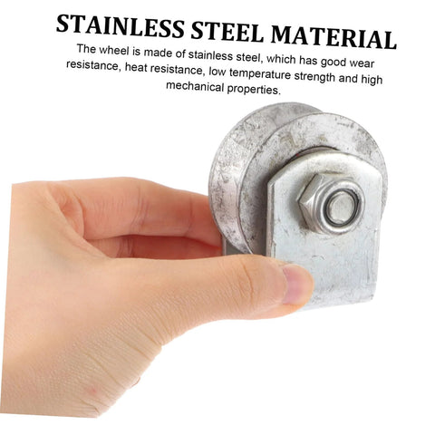 Hand holding 4-inch V-groove gate wheel made of stainless steel for sliding gates and industrial use, highlighting durability and strength.