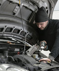 Side view of mechanic under car hood using Leberna 5–33mm stainless steel hose clamp tool kit.