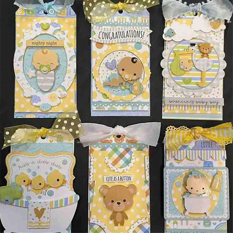Handmade baby-themed scrapbook tags with cute animal designs, ribbons, and messages like 'Cute as a Button' and 'Congrats' on yellow and blue backgrounds.