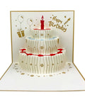 Front view of Akeydeco pop-up birthday card; white three-tier paper cake with gold accents and red candle.