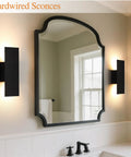 Oberade Single Hardwired Black LED Wall Light Bathroom Sconce 3000K Indoor beside a mirror in a modern bathroom setting.