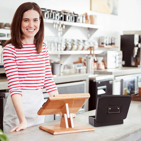 Sturdy Locking Cash Box With Pull Out Tray And Five Compartment Organizer Large Metal Safe Box For Cash Keys And Jewelry Black Sized 9.84 By 7.87 By 3.54 Inches on a counter beside a cash register in a cafe setting.