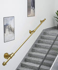 Hella Sturdy Gold Wrought Iron Handrail For Elderly And Kids Safety Stair Railing on gray stairs with wall art.