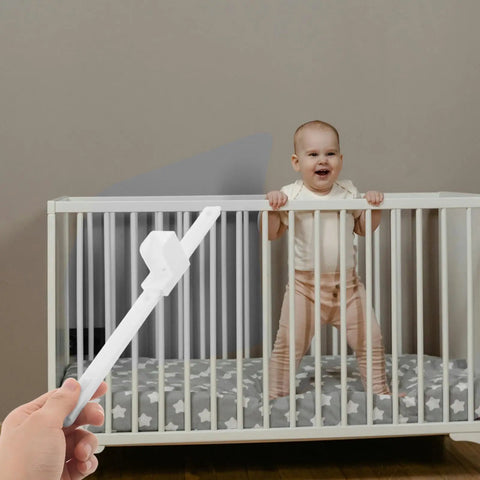 Crib Rail Lifter Kit For Easy One Hand Up And Down Bed Rails with a baby standing in a white crib, lifter kit in hand.