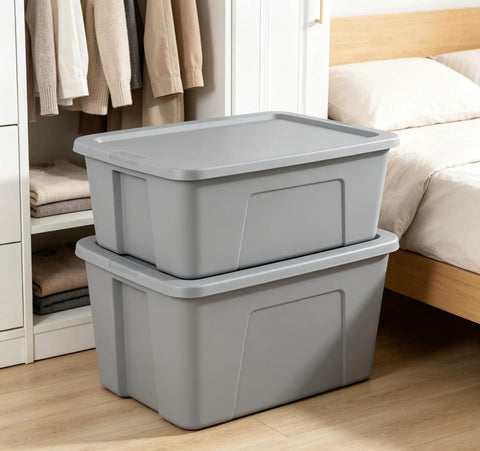 Kickass 30 Gallon Heavy Duty Plastic Storage Bin With Secure Snap Lid For Garage Organization Seasonal Gear Sorting And Everyday Essentials In Matte Gray Finish stacked next to a bed.