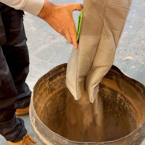 Man emptying Reusable Dust Bag For Festool Midi CT 15 E And CT 25 HEPA Dust Extractors into a large container.