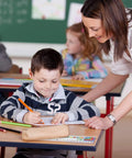 Teacher assisting student using 36 Piece Classroom Name Plates For Desks With Alphabet And Math Labels Multipurpose Manuscript Name Tags.