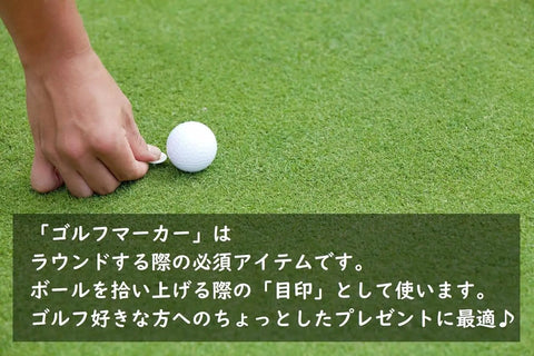 Person placing Swinging Bear Golf Ball Marker With Magnetic Hat Clip on golf course next to a golf ball.