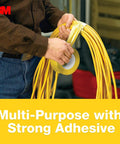 Person using Yellow Colored Duct Tape with Strong Adhesive and Water-Resistant Backing for Indoor & Outdoor Multi-Surface Use to wrap cables.