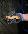 Gloved hand holding compact folding hex key set with 25 sizes in metric and SAE plus Torx keys, industrial-strength, orange handle.