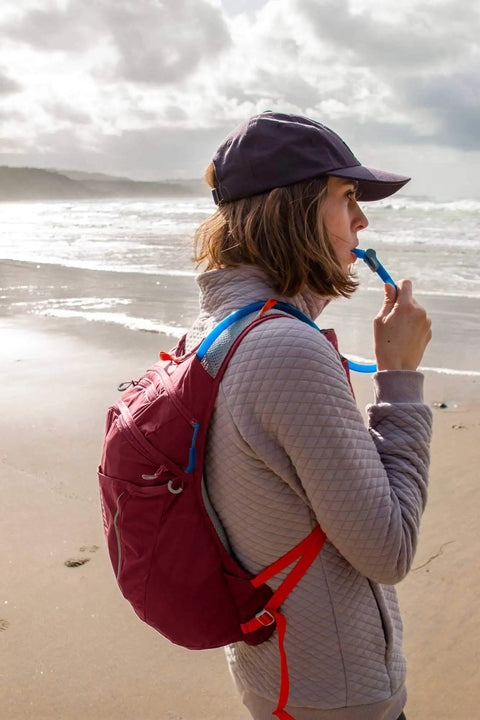 Reservoir Big Bite Valve Set In Multi Color For Hydration Systems, One Size Fits All Reservoirs, Self Seals After Each Sip To Stop Drips, Patented One Piece Silicone Design, Lifetime Guarantee on hiker drinking at beach