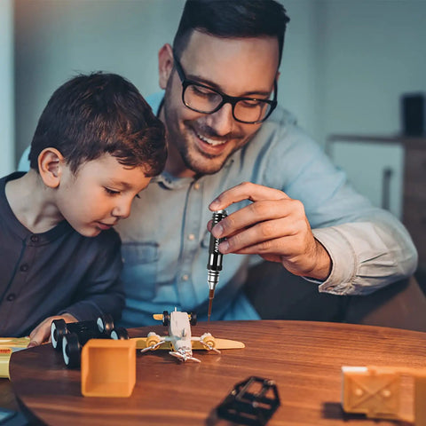 Father and son using 12-In-1 RC Screwdriver Set Dope Tool Kit with S2 Steel Bits for RC cars and hobby repairs on model.