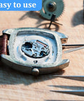 Watch repair toolkit with precision screwdriver and tweezers beside an open square watch case showing movement