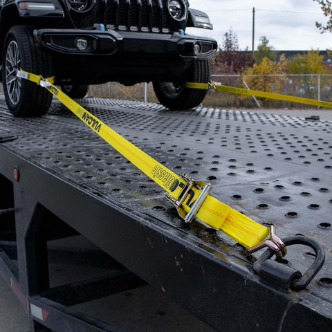 Complete Axle Strap Tie Down Kit With Wire Hook Ratchet Straps In Classic Yellow securing vehicle on trailer
