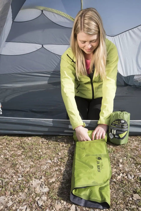 Person setting up Static V2 Dope Inflatable Sleeping Pad For Camping And Backpacking Ultralight Portable Air Bed in a tent