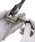 Drive chain breaker tool clamped to a 116-link motorcycle chain with a threaded bolt and gloved hands
