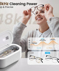 Woman holding glasses near Heavy Duty Ultrasonic Jewelry Cleaner With 30W Output And 48KHz Waves To Crush Embedded Grime, showing clean results.