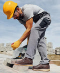 Construction worker cutting bricks wearing Six Inch Waterproof Moc Toe Steel Toe Work Boots For Men With Full Grain Leather