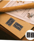 Vintage Bronze Cabinet Hinges With Screws For Wooden Boxes on a table with a hammer and instructions.