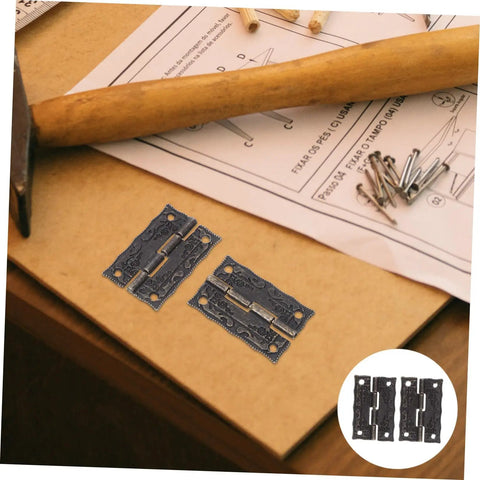 Vintage Bronze Cabinet Hinges With Screws For Wooden Boxes on a table with a hammer and instructions.