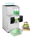 Kickstart Your Beverage Game With This Killer Commercial Snow Cone Shaver Cranking Out Up To 440 Pounds Of Fluffy Snowflake Ice Daily Via Sharp Steel Blades And Air Cooling With Two Sturdy Buckets. Silver snow cone shaver with green ice shavings and water container.