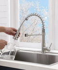 Brushed Nickel Kitchen Faucet With Pull Down Sprayer in use over stainless steel sink, spring design, single handle, modern style