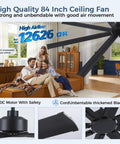 Badass 84 Inch Industrial Ceiling Fan With Reversible DC Motor And Eight Robust Blades Delivers Six Speed Remote Control Hella Quiet Airflow For Massive Garages And Shops In Matte Black displayed in a living room setting.