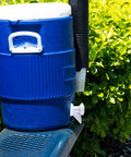 Blue cooler with push button spigot installed outdoors, showcasing Push Button Cooler Spigot Replacement 3 Pack White For 2 To 10 Gallon Beverage Coolers Durable Water Dispenser Spigots Ideal For Outdoor Parties And Home Use.